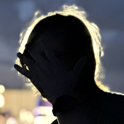 silhouette of a human covering his face with a hand